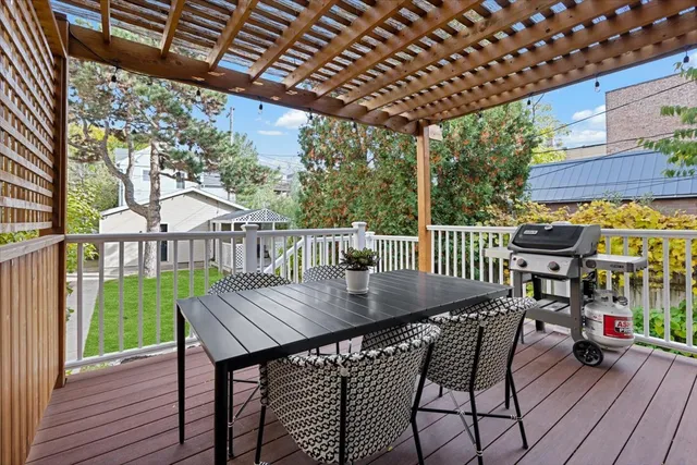 a view of a patio with table and chairs with wooden floor and fence