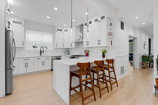 a kitchen with white cabinets and stainless steel appliances