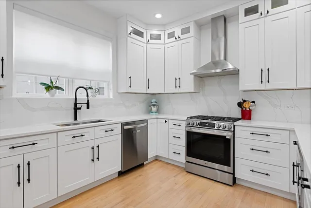a kitchen with white cabinets and sink