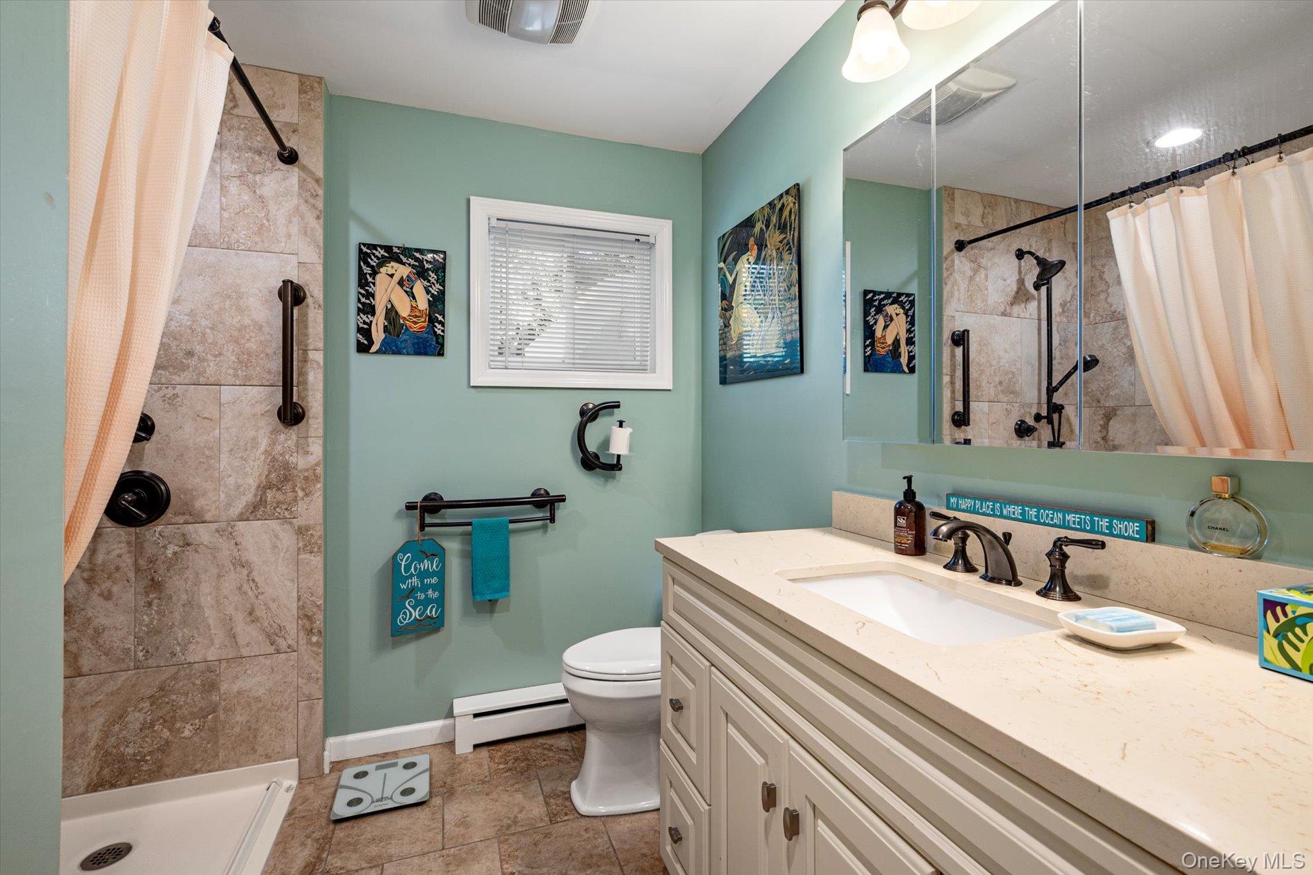 65 Harriet Road North Babylon, NY 11703 - Photo 11 of 31 Full bathroom featuring baseboard heating, a stall shower, vanity, and dark tile patterned floors
