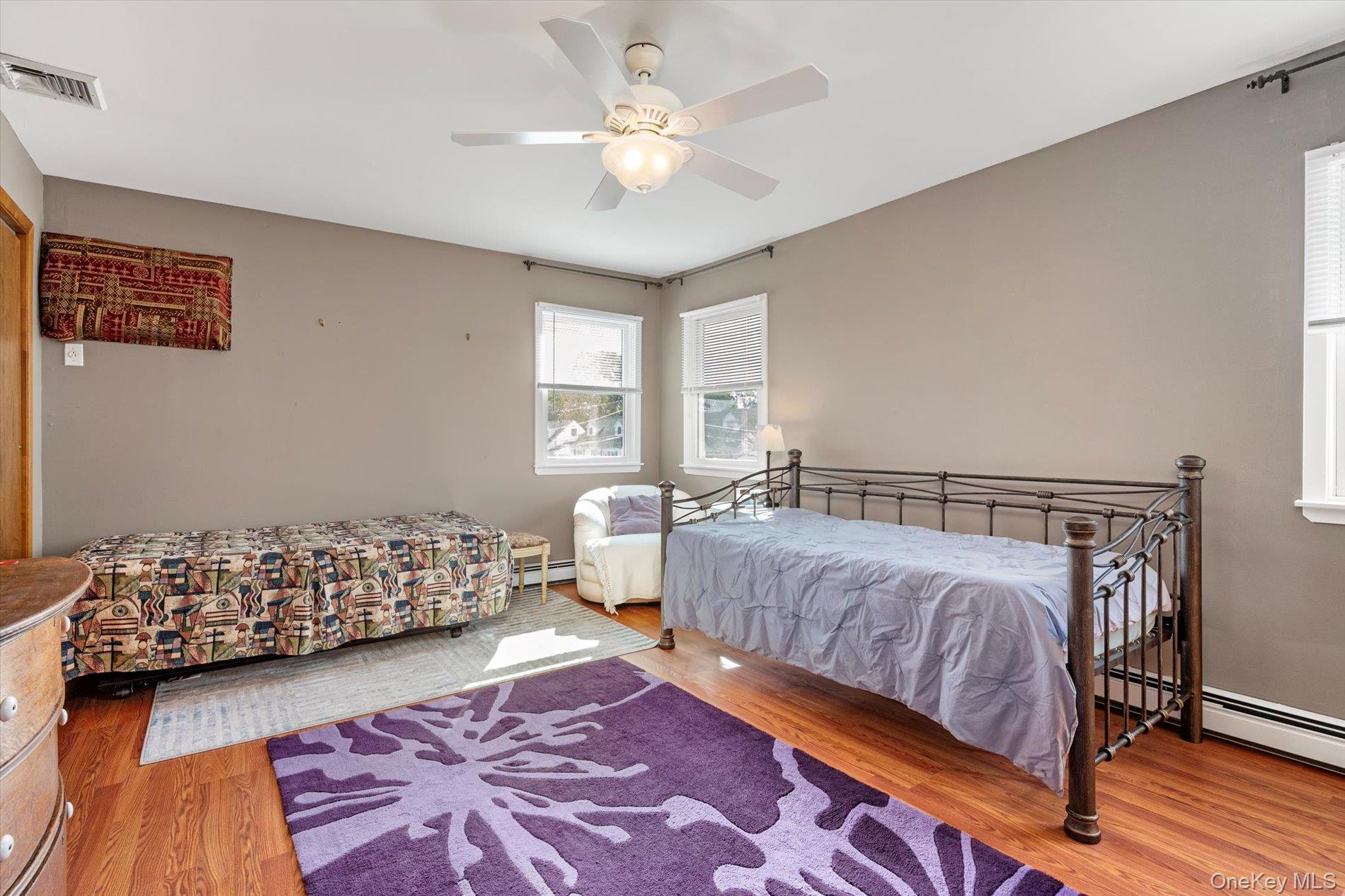 65 Harriet Road North Babylon, NY 11703 - Photo 16 of 31 Bedroom featuring wood finished floors, ceiling fan, and baseboard heating
