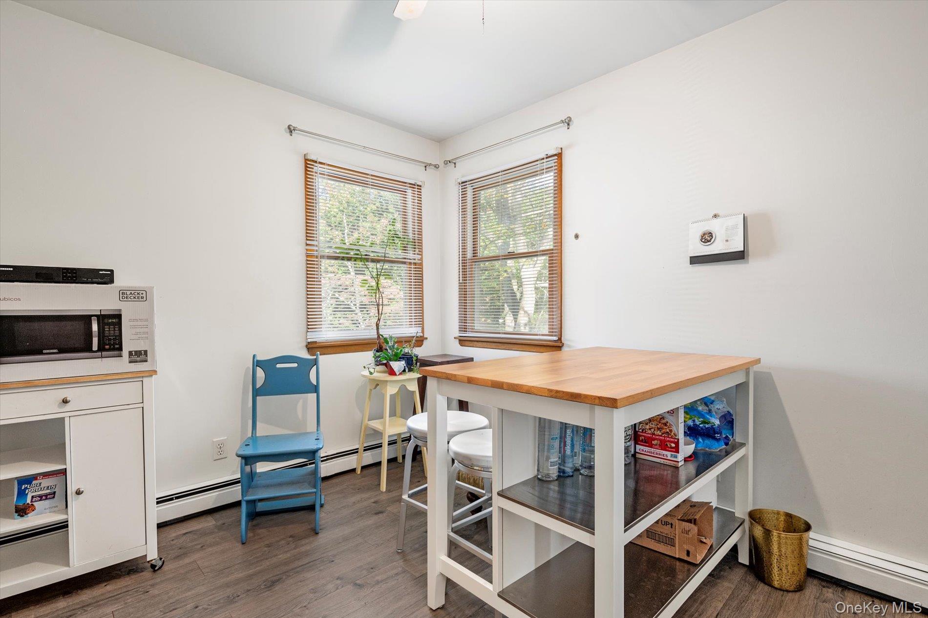 65 Harriet Road North Babylon, NY 11703 - Photo 18 of 31 Dining space with dark wood-type flooring and a baseboard heating unit