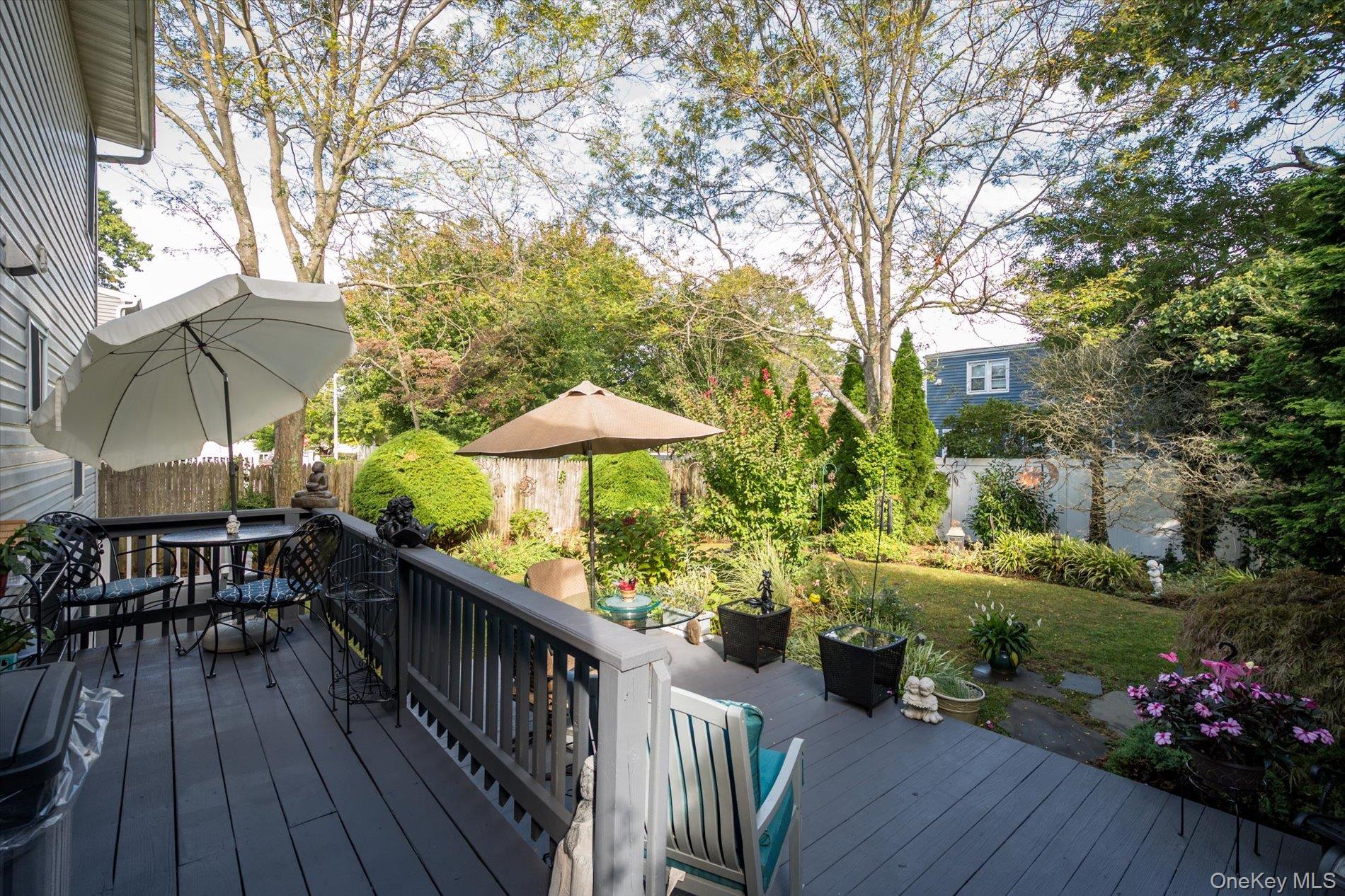 65 Harriet Road North Babylon, NY 11703 - Photo 23 of 31 Deck with outdoor dining space and view of wooded area