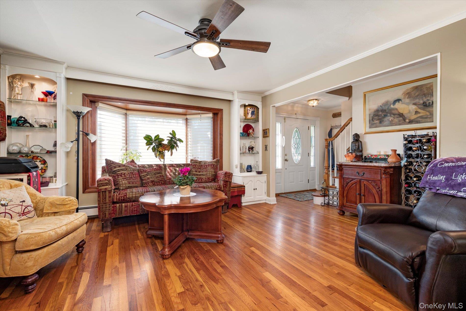 65 Harriet Road North Babylon, NY 11703 - Photo 6 of 31 Living area with wood finished floors, built in shelves, ceiling fan, stairway, and ornamental molding