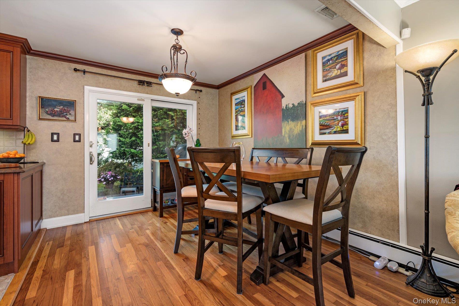 65 Harriet Road North Babylon, NY 11703 - Photo 7 of 31 Dining space with crown molding, light wood-type flooring, and a baseboard heating unit