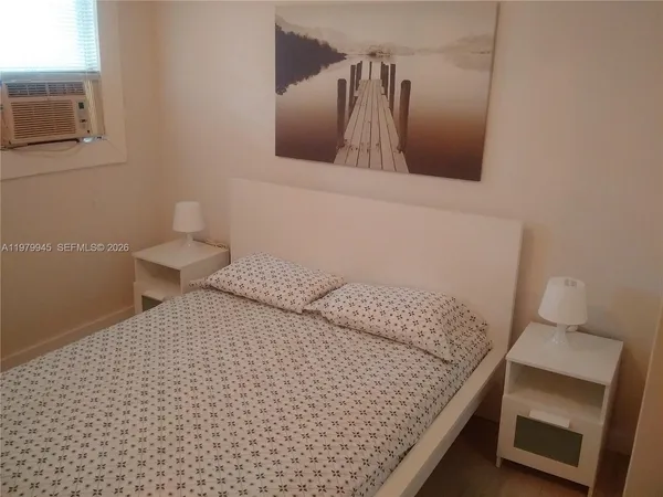 a bedroom with a bed and teddy bear on bed