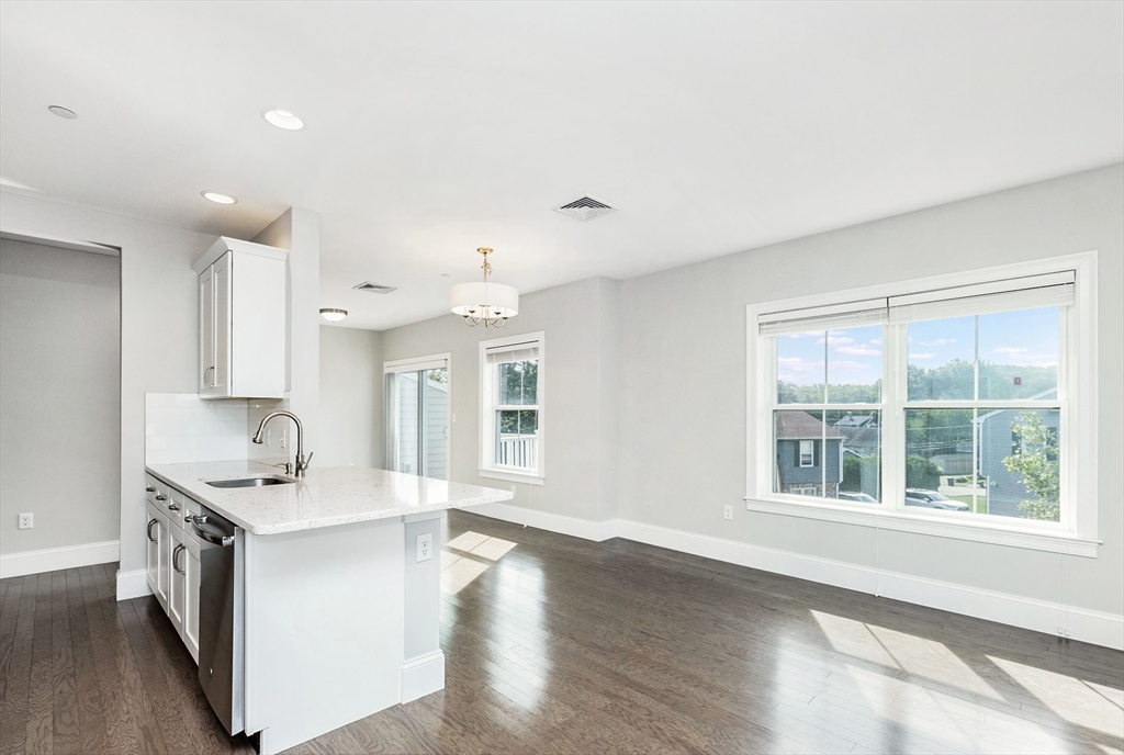 445 Essex Street, Unit 304 Swampscott, MA 01907 - Photo 12 of 35 a kitchen with granite countertop a sink and cabinets