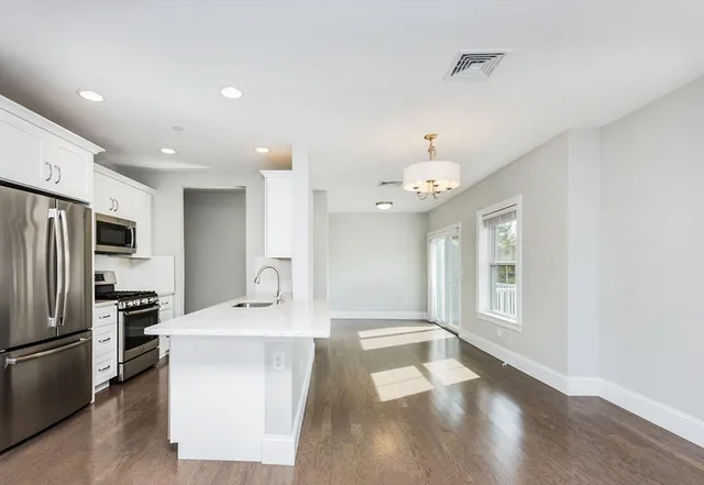 a large kitchen with a sink a refrigerator and a stove