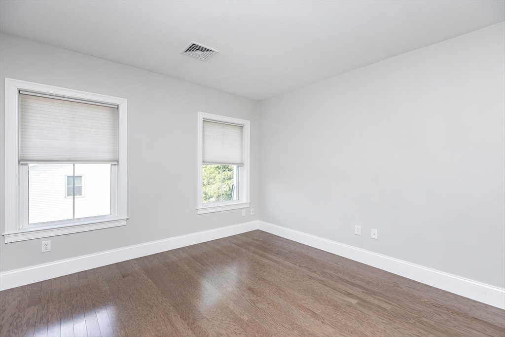 445 Essex Street, Unit 304 Swampscott, MA 01907 - Photo 19 of 35 an empty room with wooden floor and windows