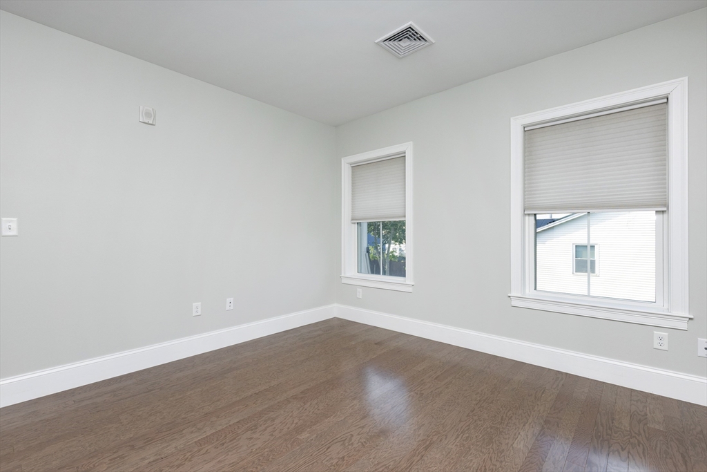 445 Essex Street, Unit 304 Swampscott, MA 01907 - Photo 23 of 35 an empty room with wooden floor and windows