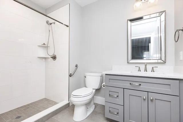 a bathroom with a toilet sink vanity and mirror
