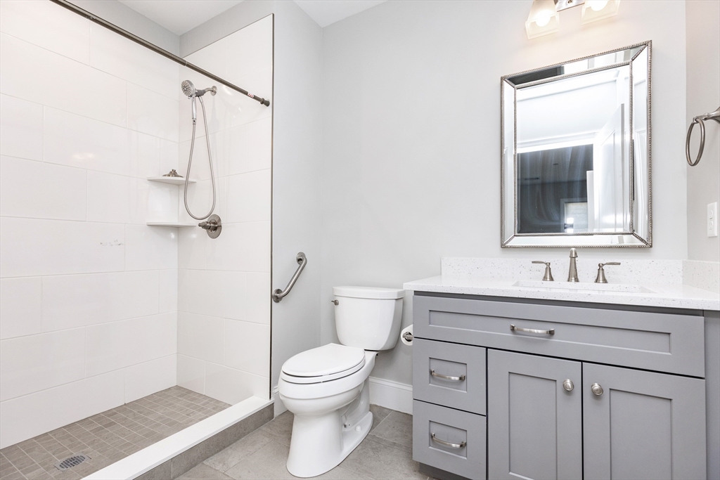445 Essex Street, Unit 304 Swampscott, MA 01907 - Photo 24 of 35 a bathroom with a toilet sink vanity and mirror