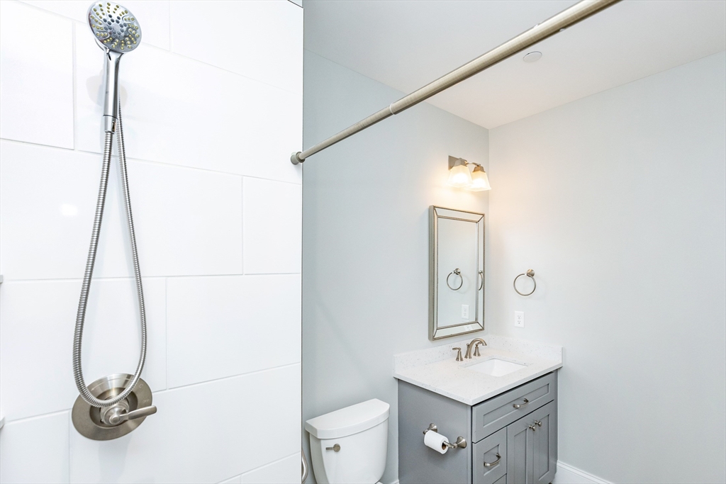 445 Essex Street, Unit 304 Swampscott, MA 01907 - Photo 25 of 35 a bathroom with a sink a toilet and mirror