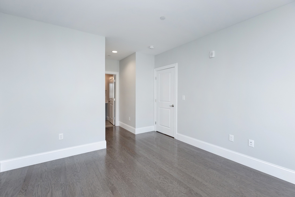 445 Essex Street, Unit 304 Swampscott, MA 01907 - Photo 26 of 35 a view of an empty room with wooden floor and a window