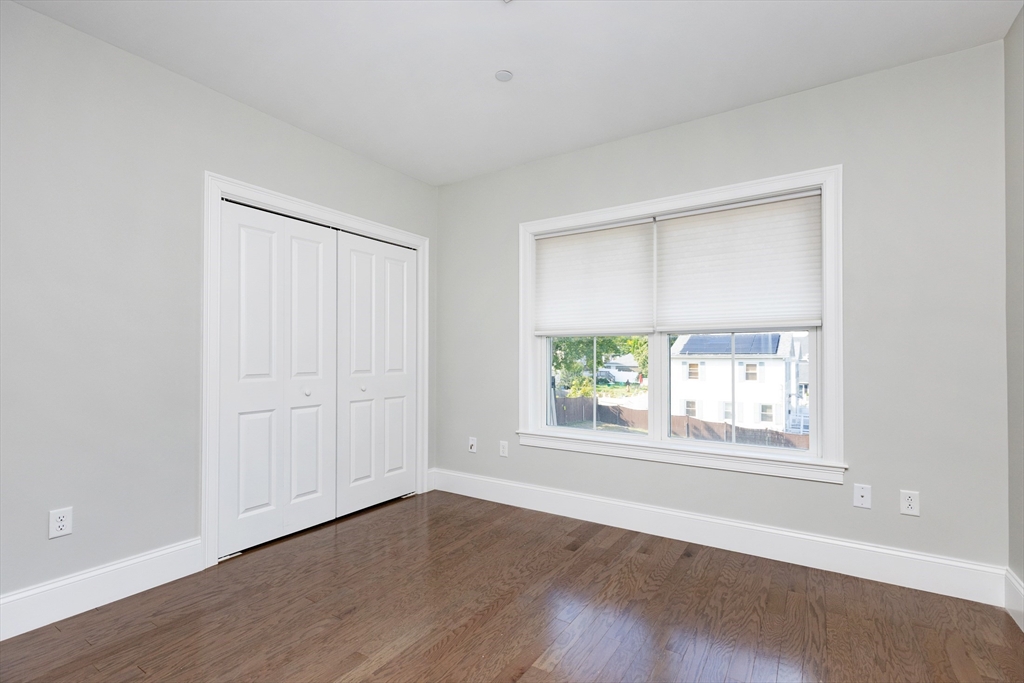 445 Essex Street, Unit 304 Swampscott, MA 01907 - Photo 27 of 35 an empty room with wooden floor and windows