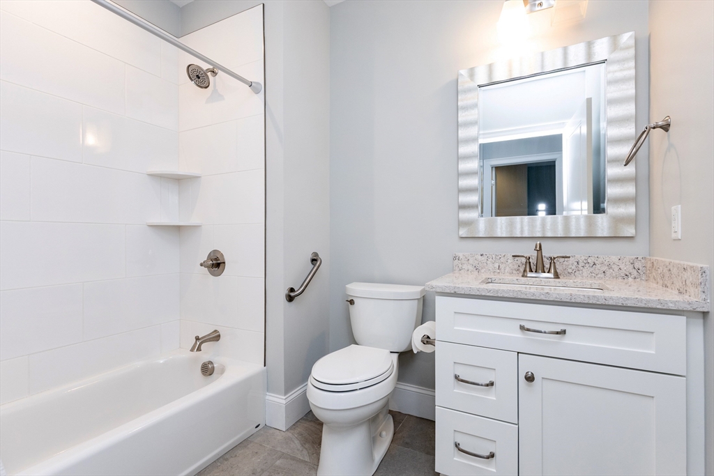 445 Essex Street, Unit 304 Swampscott, MA 01907 - Photo 30 of 35 a bathroom with a granite countertop sink toilet and shower