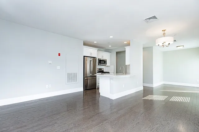 a view of kitchen with refrigerator and window