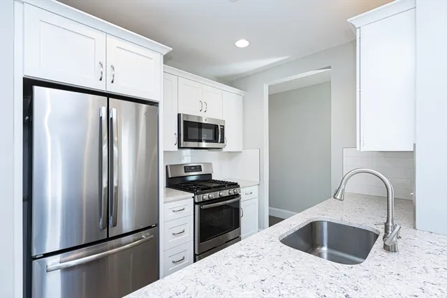 a kitchen with stainless steel appliances a refrigerator sink and microwave