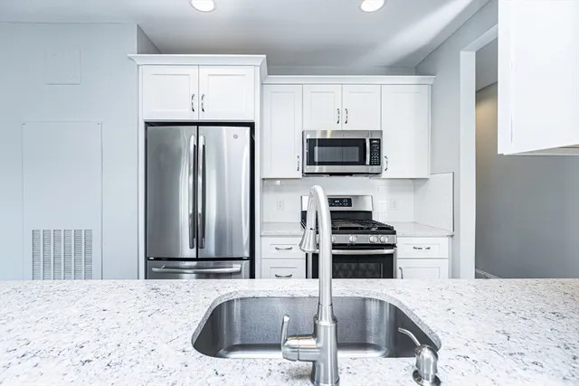 a kitchen with kitchen island a sink stove and refrigerator