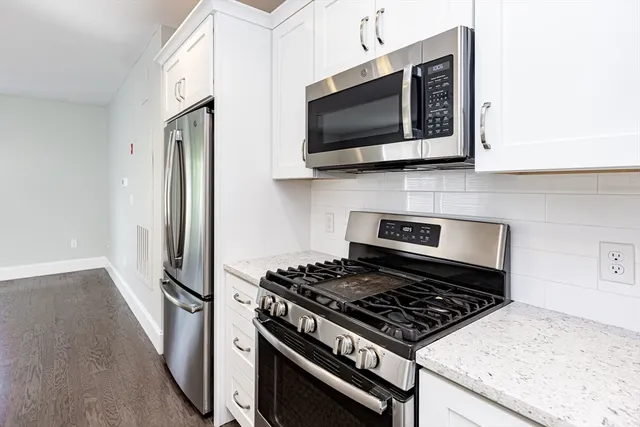 a kitchen with stainless steel appliances granite countertop a stove and a microwave