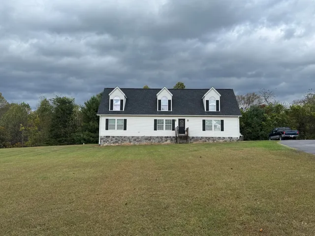 a view of a big house with a big yard and large trees