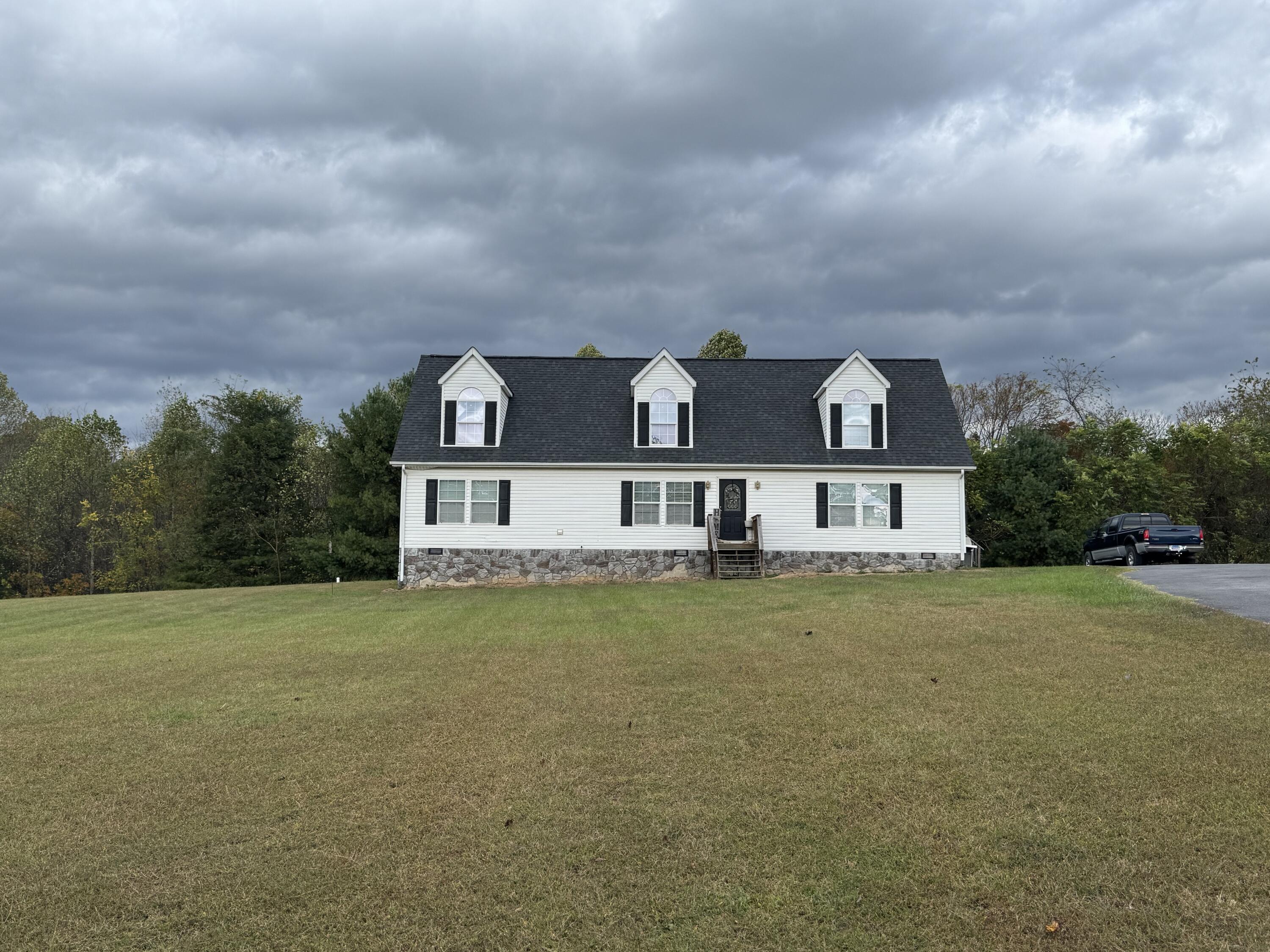 a view of a big house with a big yard and large trees