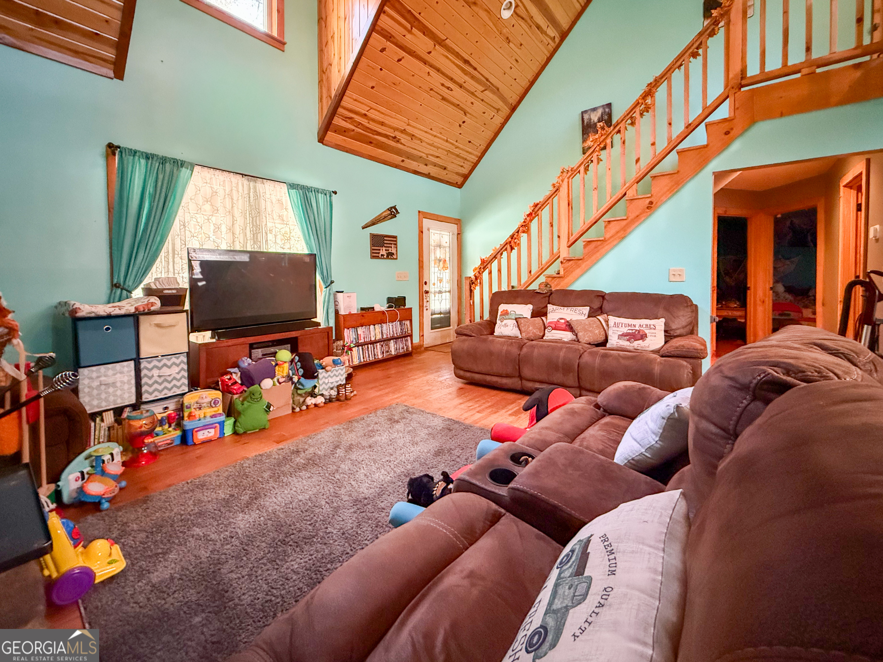 161 Twisting Ridge Trail Demorest, GA 30535 - Photo 4 of 33 a living room with furniture a flat screen tv and a floor to ceiling window