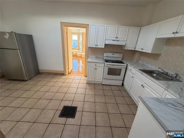 a kitchen with a sink a stove and a refrigerator