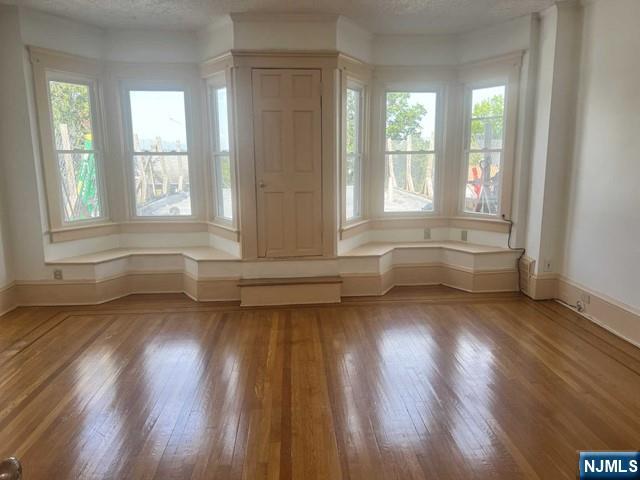 212 Main Street Ridgefield Park, NJ 07660 - Photo 3 of 12 a view of an empty room with wooden floor and a window