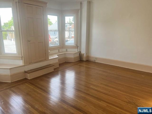 212 Main Street Ridgefield Park, NJ 07660 - Photo 4 of 12 an empty room with wooden floor and windows