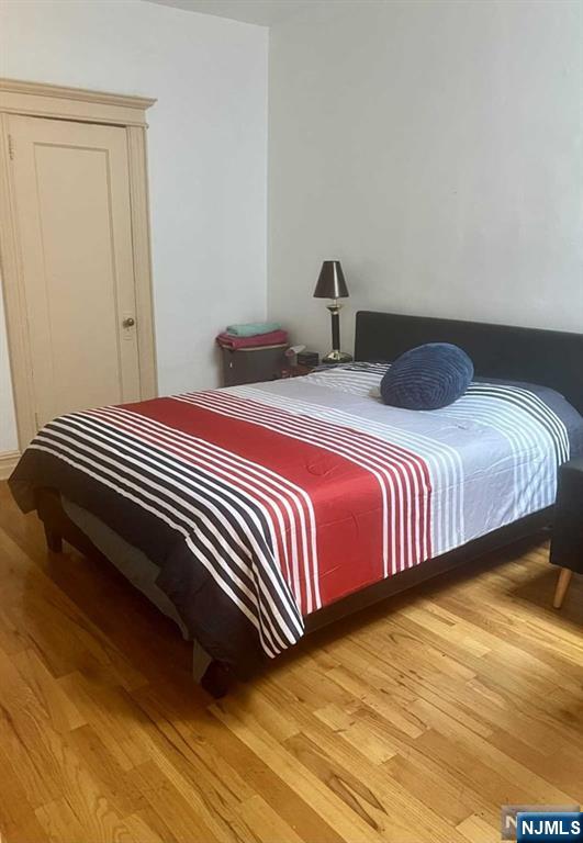 212 Main Street Ridgefield Park, NJ 07660 - Photo 6 of 12 a bedroom with a bed and wooden floor