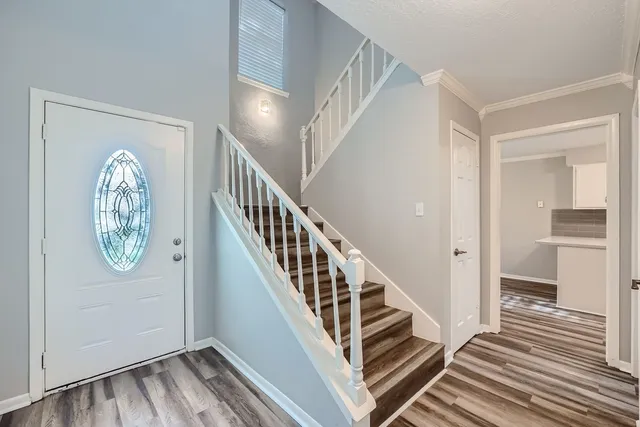 a view of a hallway with wooden floor and entryway
