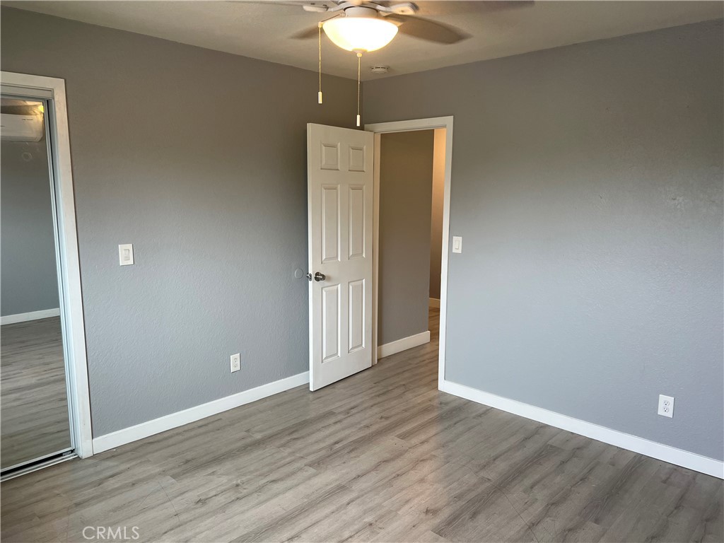 136 West 53rd Street, Unit A Long Beach, CA 90805 - Photo 13 of 13 an empty room with wooden floor and chandelier fan