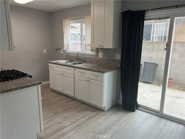 a kitchen with granite countertop a sink and a stove