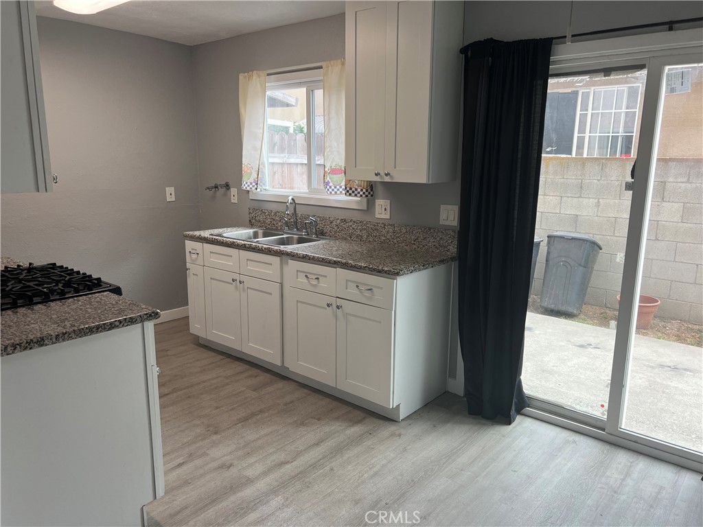 136 West 53rd Street, Unit A Long Beach, CA 90805 - Photo 5 of 13 a kitchen with granite countertop a sink and a stove