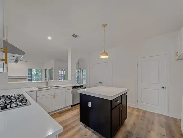 a kitchen with a sink stove and cabinets