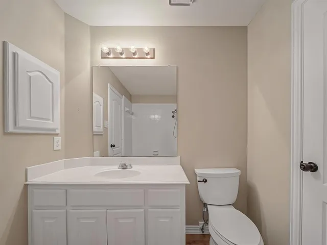 a bathroom with a toilet a sink and mirror