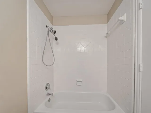 a bathroom with a bath tub with a shower