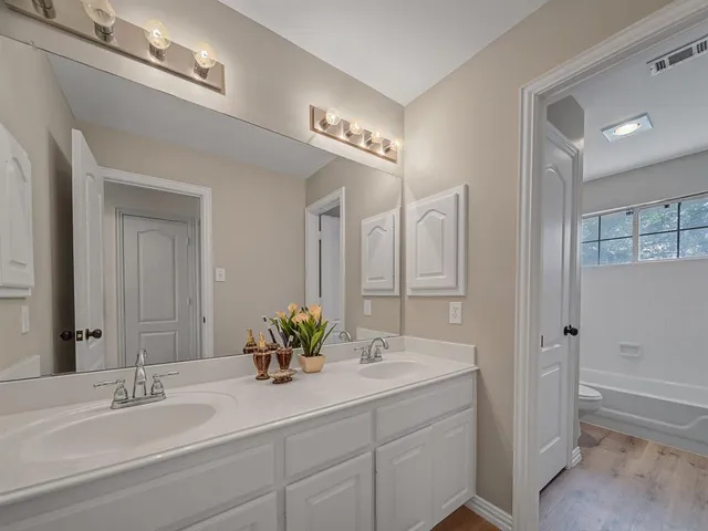 a bathroom with a double vanity sink and a mirror