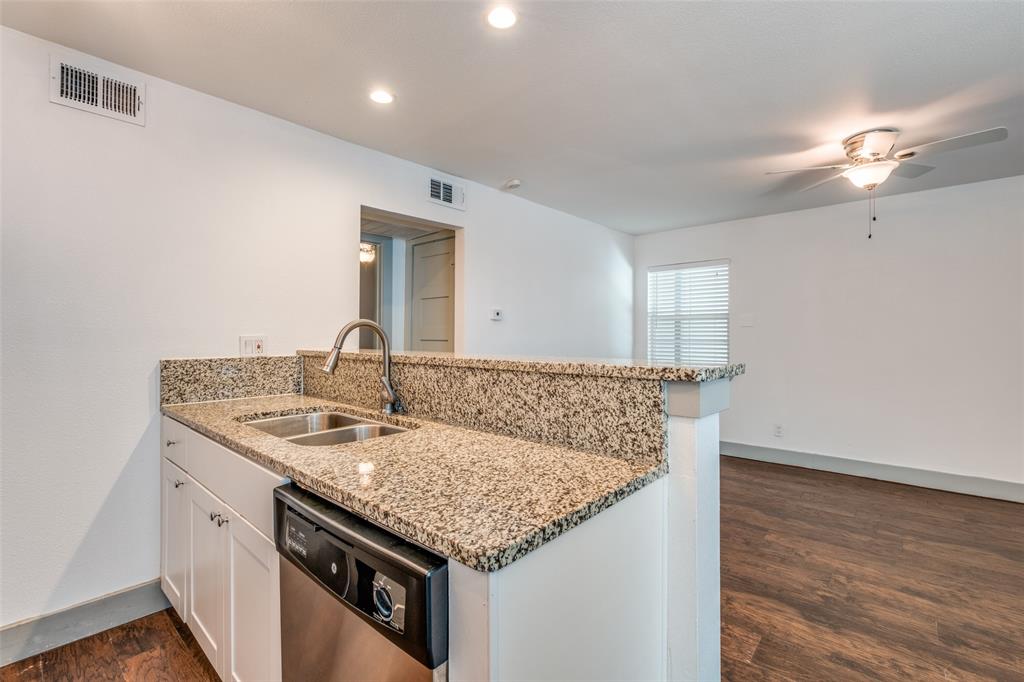 4633 Fairmount Street, Unit 109 Dallas, TX 75219 - Photo 10 of 14 Kitchen bar with stone-finish countertop, double basin sink, and stainless steel dishwasher