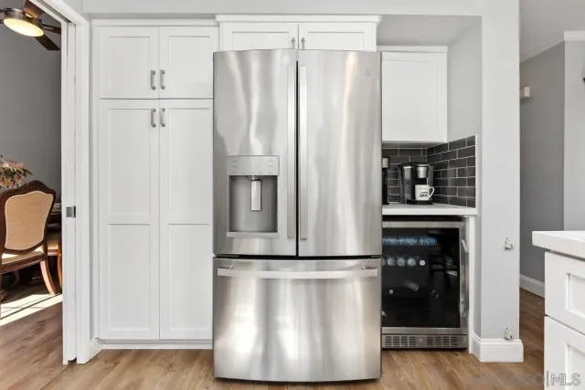 a kitchen with appliances a refrigerator and cabinets