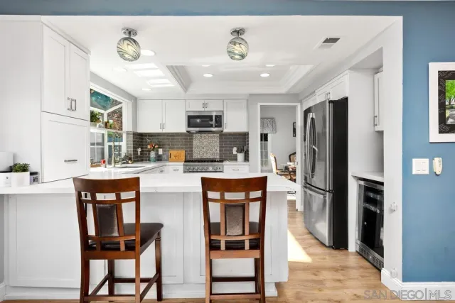 a kitchen with stainless steel appliances kitchen island granite countertop a refrigerator and a stove top oven