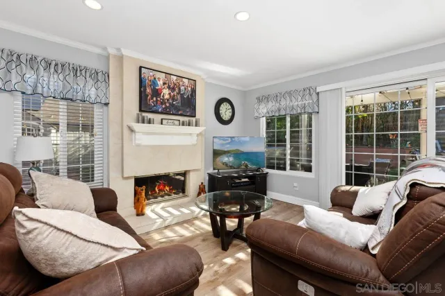 a living room with furniture a fireplace and a large window