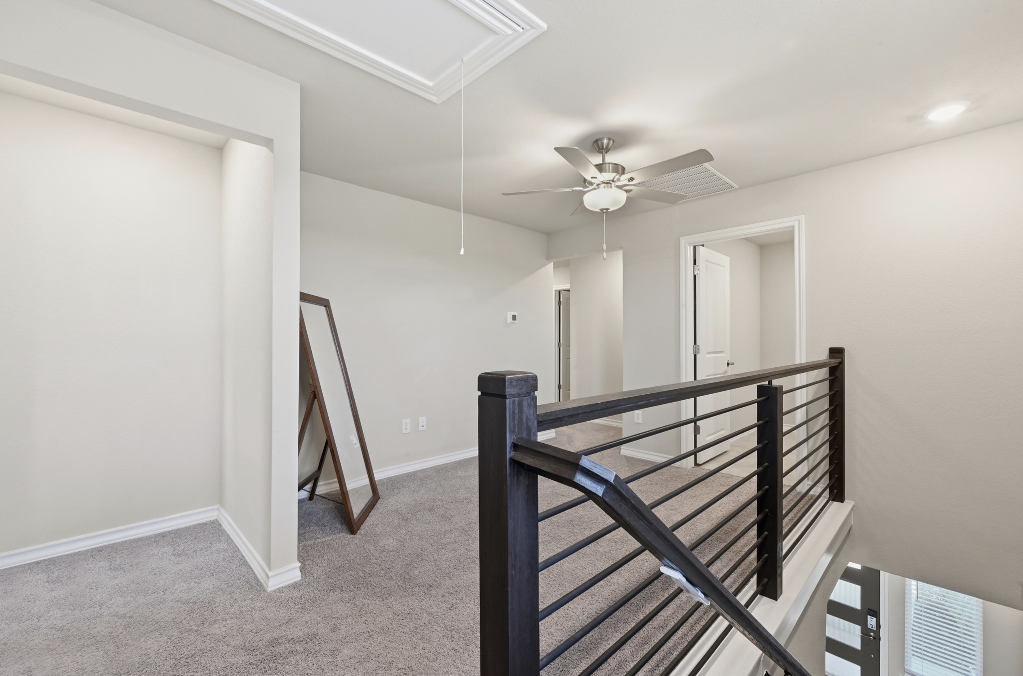 488 Pepperbark Loop Buda, TX 78610 - Photo 16 of 31 An inviting upper-level loft offers comfortable carpeting and a modern ceiling fan for year-round comfort.