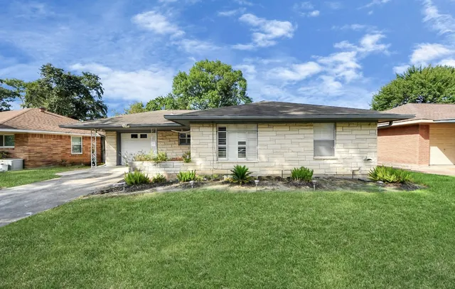 a front view of a house with a garden