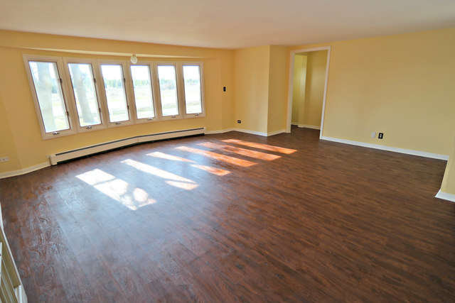 3516 Lily Pond Road Woodstock, IL 60098 - Photo 6 of 20 an empty room with wooden floor and windows