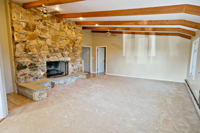 3516 Lily Pond Road Woodstock, IL 60098 - Photo 7 of 20 a view of a livingroom with an empty space and a fireplace