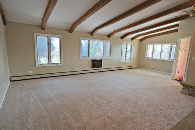 3516 Lily Pond Road Woodstock, IL 60098 - Photo 8 of 20 a view of an empty room with a fireplace and a window