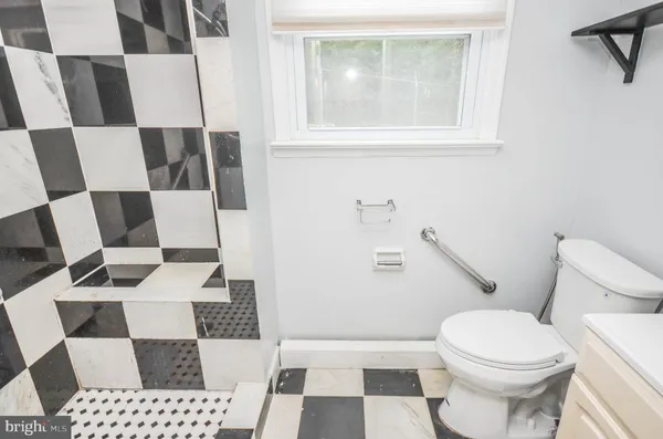 a white toilet sitting next to a bathroom sink and a mirror