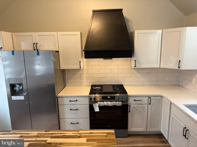 a kitchen with granite countertop a stove a refrigerator and a sink